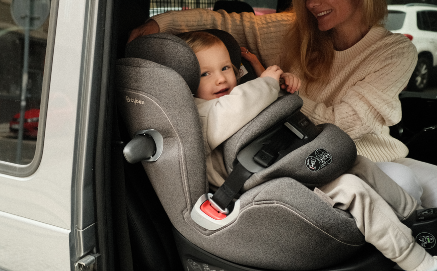 bambino che viaggia in auto con seggiolino