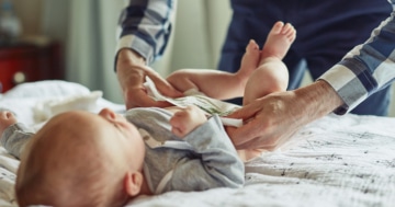 papà cambia pannolino neonato