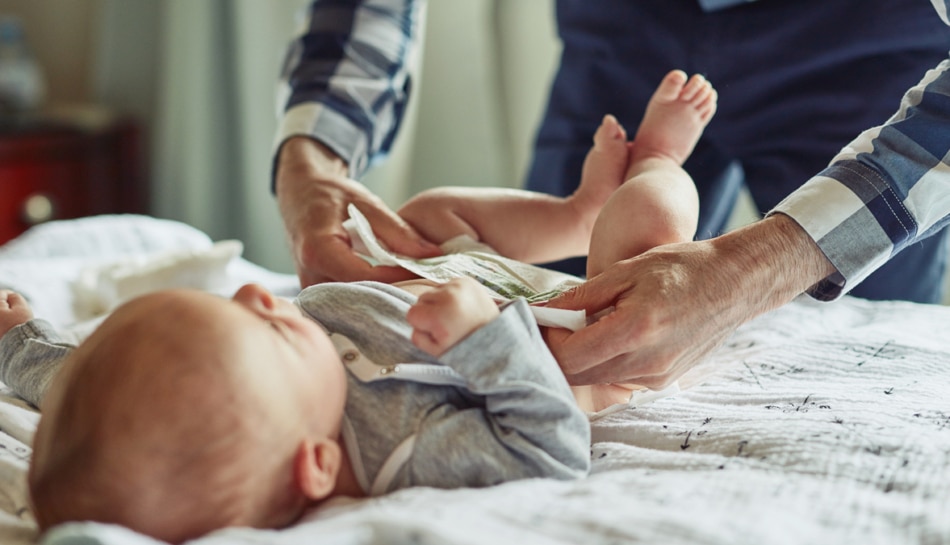 papà cambia pannolino neonato