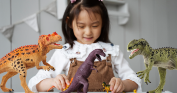 bambina gioca con i dinosauri