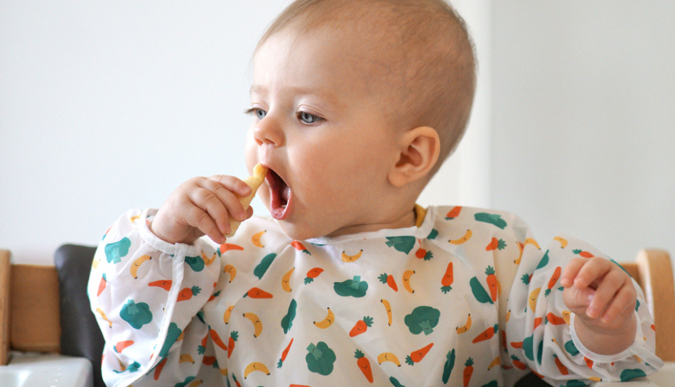 Bambino mangia la sua prima pappa durante lo svezzamento