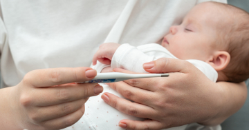 Madre controlla febbre al bambino con virus sinciziale