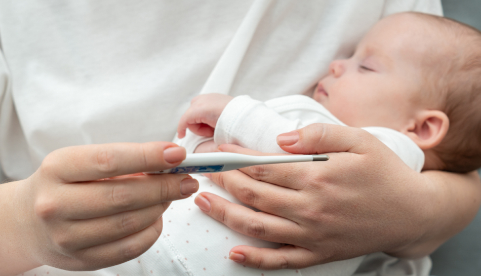 Madre controlla febbre al bambino con virus sinciziale