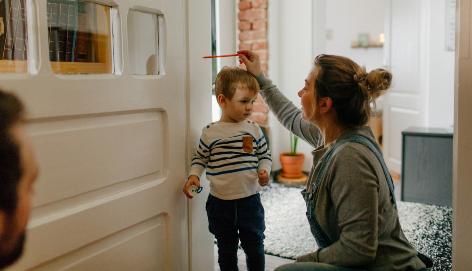 Genitori misurano l'altezza del figlio