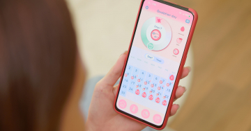 Donna controlla su app calendario del ciclo mestruale