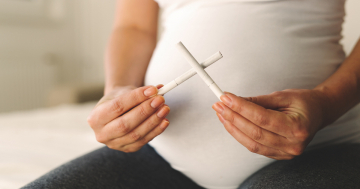 Donna incinta con sigarette intonse in mano