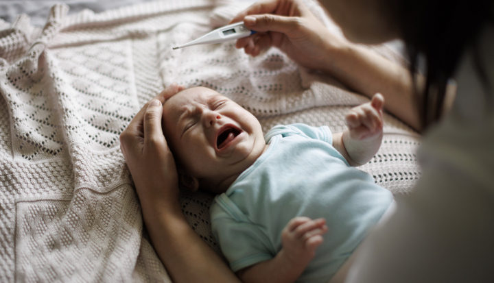 Donna misura la febbre al proprio bambino