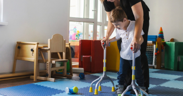 Bambino affetto da spina bifida fa fisioterapia