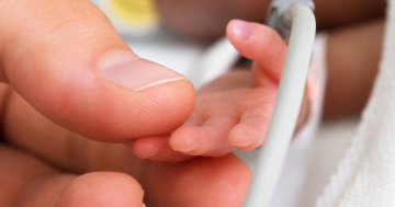 Genitore tocca la mano del neonato