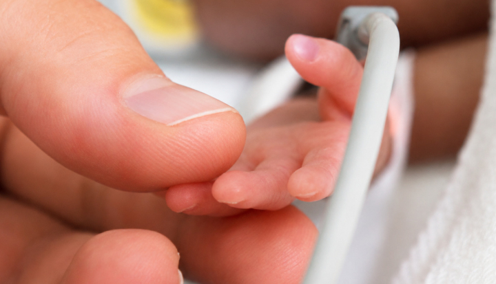 Genitore tocca la mano del neonato